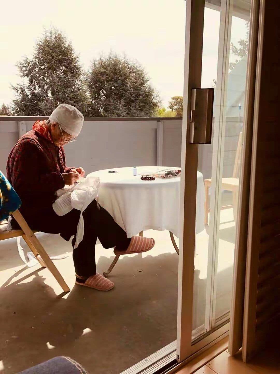 Our mother, 99, sewing by hand in the sunshine on her balcony.