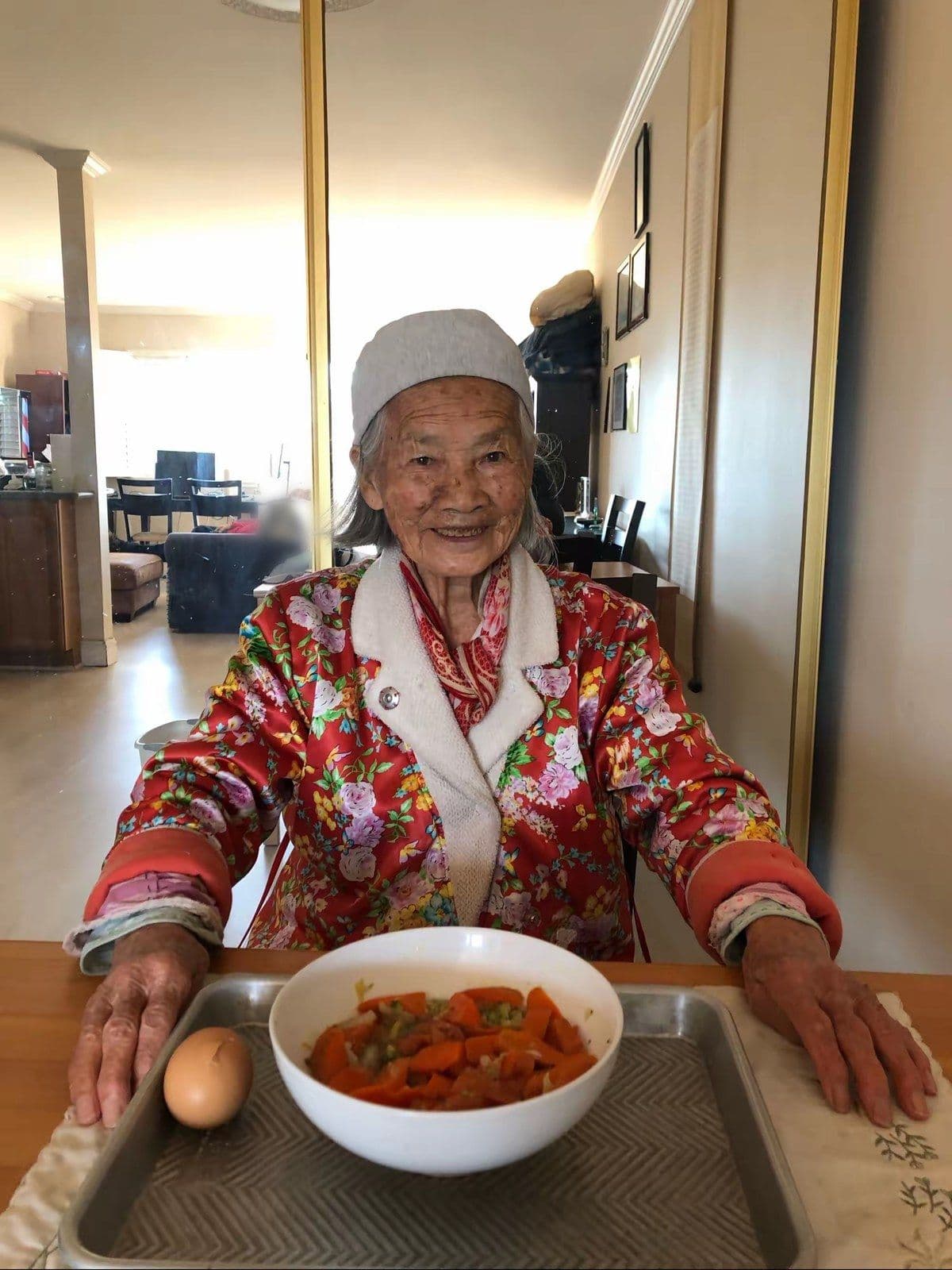Our mother, 99, smiling over her lunch of carrots and a boiled egg.